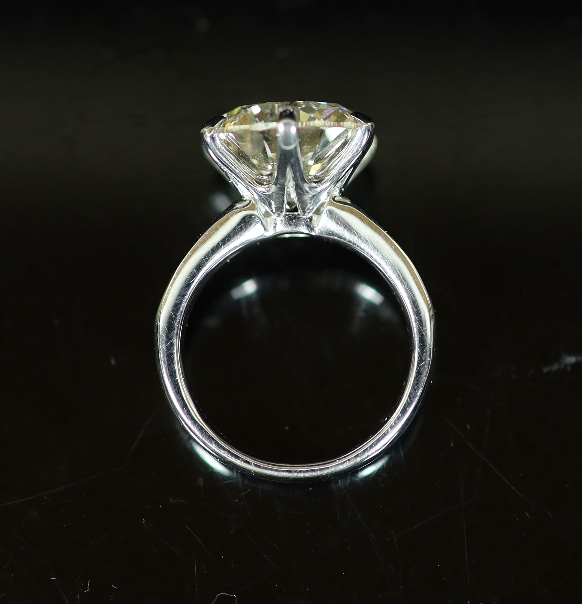 A modern platinum and single stone diamond ring, with diamond set shoulders, with AGI Laboratories report dated 23/5/2016, stating the round brilliant cut stone to weigh 7.77cts